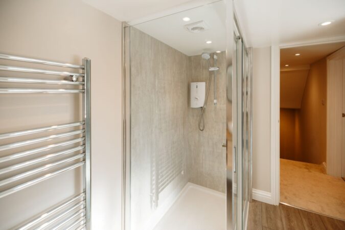 Contemporary shower room with walk-in glass enclosure and neutral tones at The Hideaway