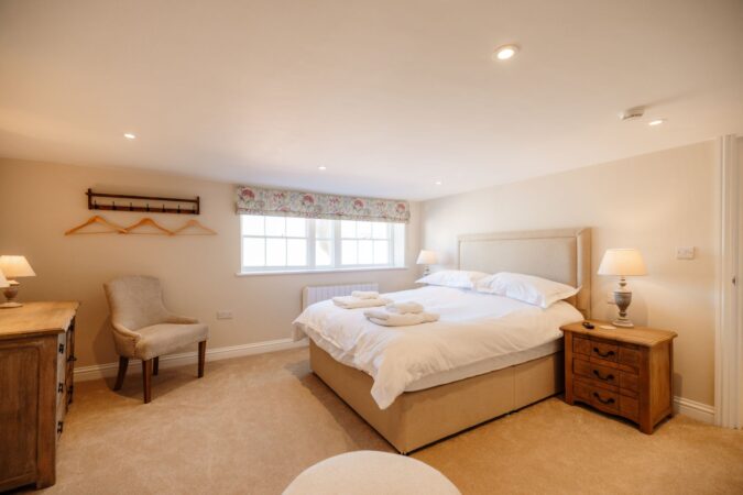 Stylish king-size bedroom with soft coastal-themed decor at The Hideaway in Whitby