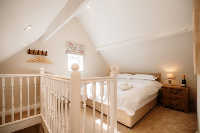 Loft king-size bedroom with sloped ceilings at The Hideaway holiday cottage