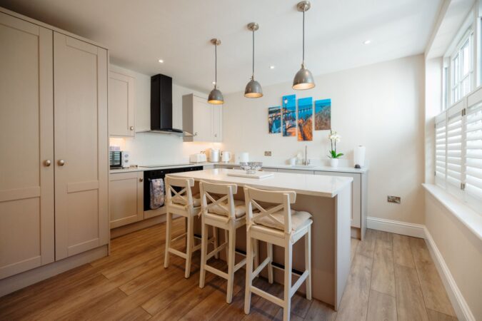 Modern kitchen with large breakfast island with seating at The Hideaway holiday cottage