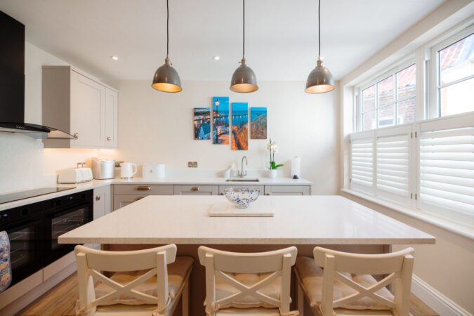 Modern kitchen with large breakfast island with seating at The Hideaway holiday cottage